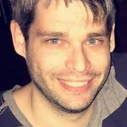 Tom Mitsos smiling with teeth.